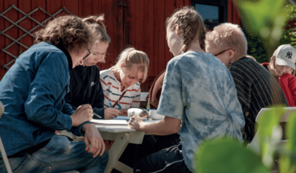 En grupp människor som sitter runt ett bord.