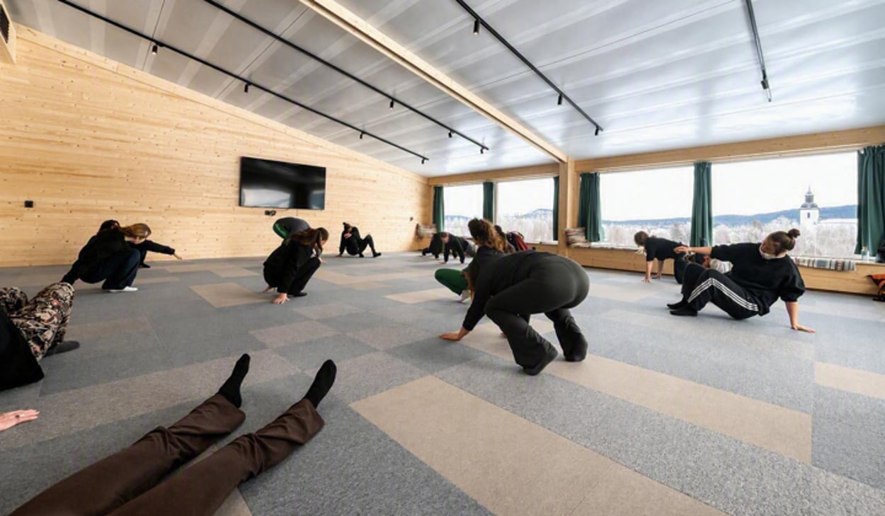 En grupp människor som gör yoga i ett stort rum.