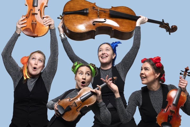 En grupp kvinnor som håller upp musikinstrument.